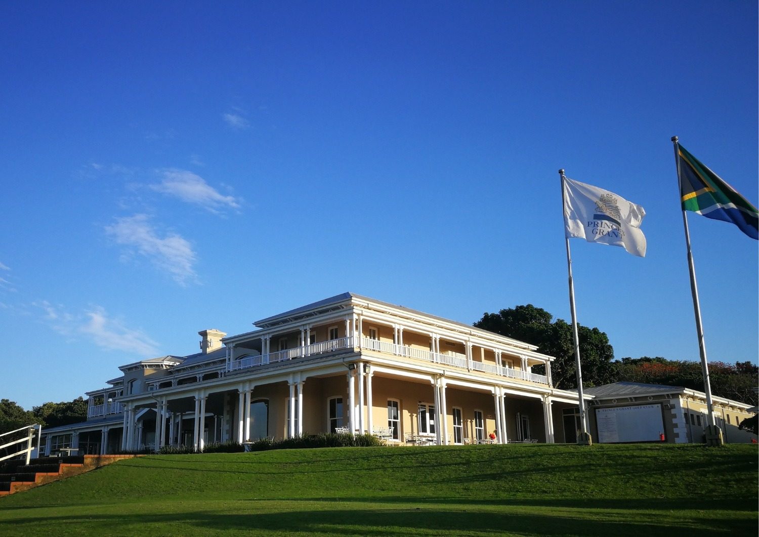 The Prince&rsquo;s Grant clubhouse above the fairway, with the club and South African flags flying